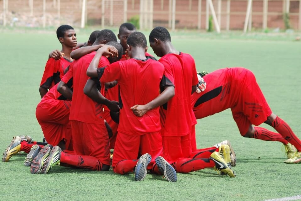 Champs City players praying after a match